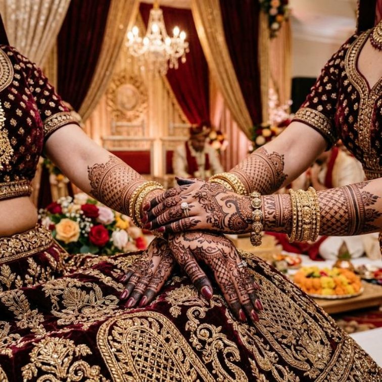 Bride's mehendi-covered hands resting together during a wedding ceremony