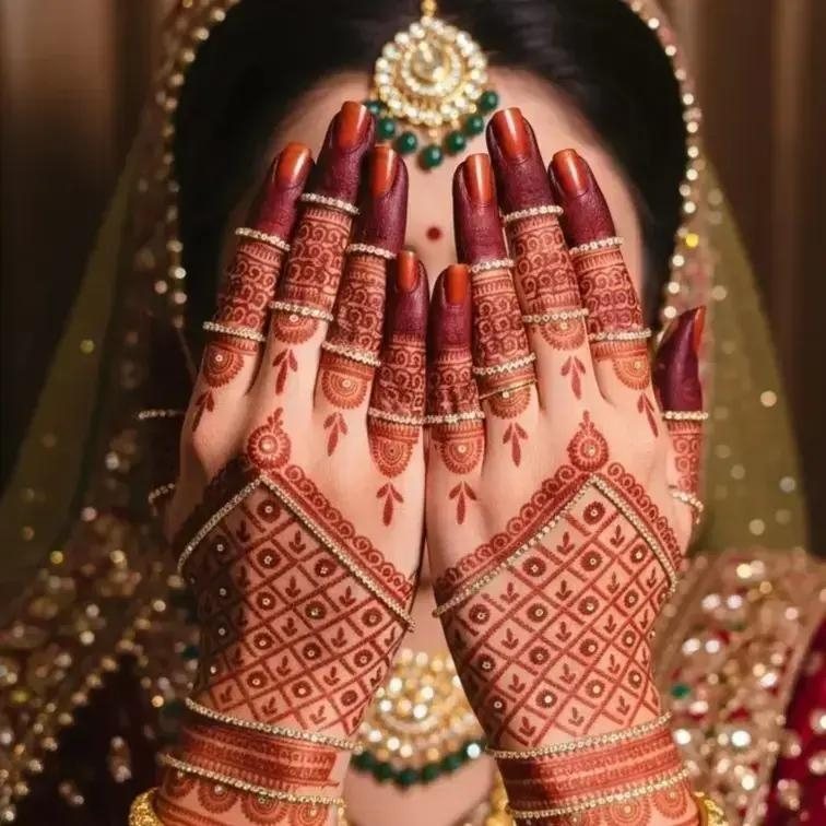 Bride's hands framing her face, decorated with intricate bridal mehendi and gold jewellery